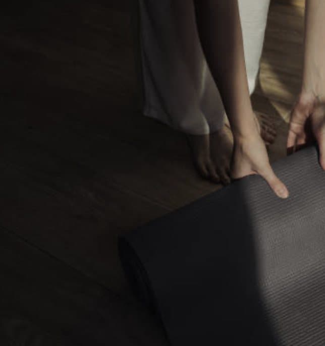 Tapis de yoga et pieds nus posés au sol dans une lumière douce